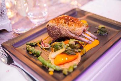 Salle de jeux lumineuse avec une cabane en tissu, un tapis de chiffres, une cuisine pour enfants et des tables colorées.