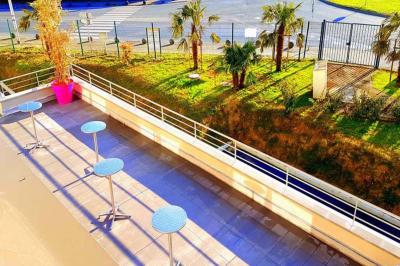 Salle de jeux lumineuse avec une cabane en tissu, un tapis de chiffres, une cuisine pour enfants et des tables colorées.