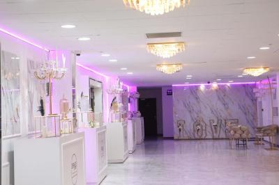 Salle de jeux lumineuse avec une cabane en tissu, un tapis de chiffres, une cuisine pour enfants et des tables colorées.