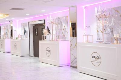 Salle de jeux lumineuse avec une cabane en tissu, un tapis de chiffres, une cuisine pour enfants et des tables colorées.