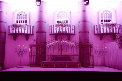 Salle de jeux lumineuse avec une cabane en tissu, un tapis de chiffres, une cuisine pour enfants et des tables colorées.