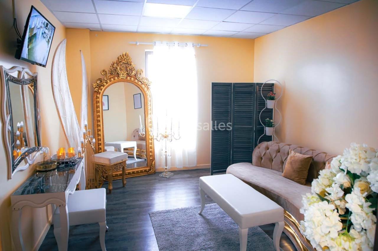 Salle lumineuse avec canapé beige, miroir doré, table basse blanche et décoration élégante dans des tons neutres.