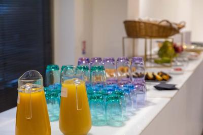 Salle de jeux lumineuse avec une cabane en tissu, un tapis de chiffres, une cuisine pour enfants et des tables colorées.