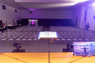Salle de jeux lumineuse avec une cabane en tissu, un tapis de chiffres, une cuisine pour enfants et des tables colorées.