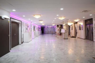 Salle de jeux lumineuse avec une cabane en tissu, un tapis de chiffres, une cuisine pour enfants et des tables colorées.