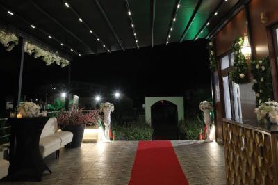 Salle de jeux lumineuse avec une cabane en tissu, un tapis de chiffres, une cuisine pour enfants et des tables colorées.