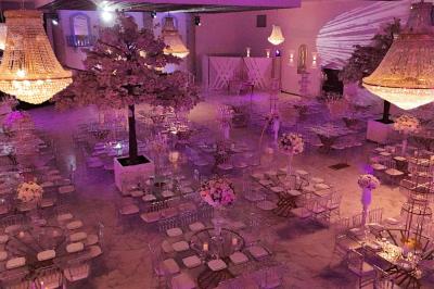 Salle de jeux lumineuse avec une cabane en tissu, un tapis de chiffres, une cuisine pour enfants et des tables colorées.