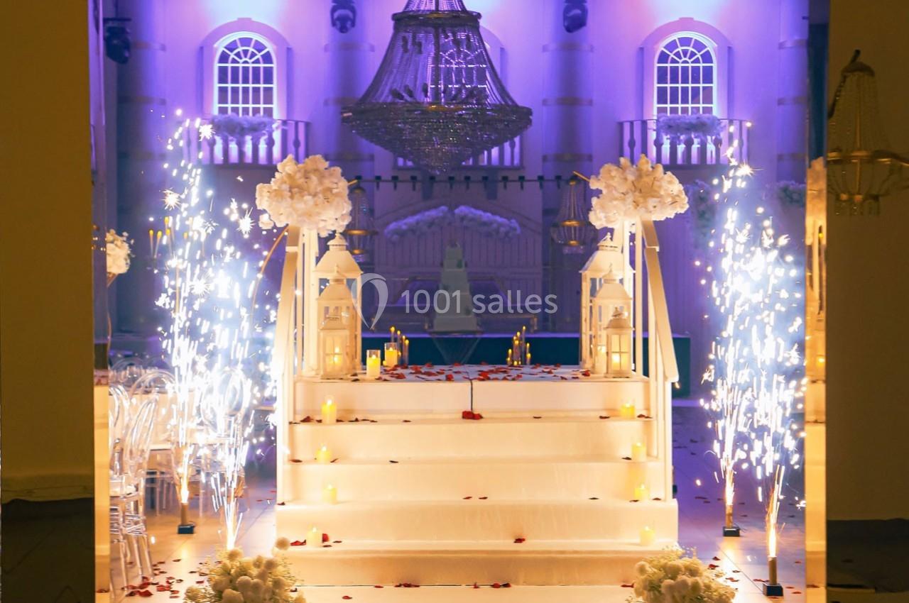 Escalier décoré de fleurs blanches, bougies et pétales rouges, entouré de feux d'artifice intérieurs sous un éclairage…