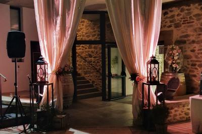 Façade en pierre d'une maison rénovée avec terrasse, grandes fenêtres et espace extérieur gravillonné.