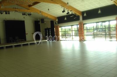 Phare blanc sur un îlot rocheux, accessible par une jetée étroite, entouré d'eau sous un ciel bleu clair.