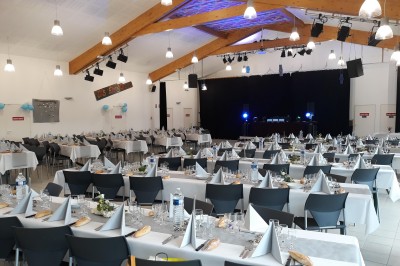 Phare blanc sur un îlot rocheux, accessible par une jetée étroite, entouré d'eau sous un ciel bleu clair.