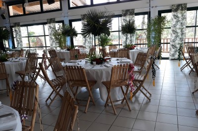 Phare blanc sur un îlot rocheux, accessible par une jetée étroite, entouré d'eau sous un ciel bleu clair.