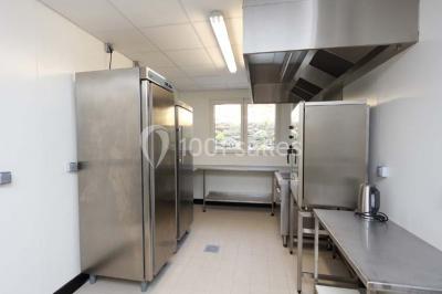 Chambre lumineuse avec deux lits, parquet au sol, murs clairs et fenêtres donnant sur un jardin verdoyant.