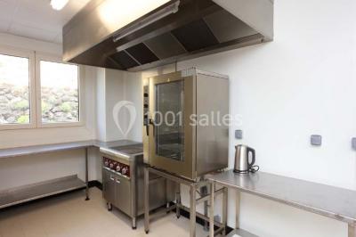 Chambre lumineuse avec deux lits, parquet au sol, murs clairs et fenêtres donnant sur un jardin verdoyant.