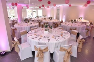 Chambre lumineuse avec deux lits, parquet au sol, murs clairs et fenêtres donnant sur un jardin verdoyant.