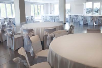 Chambre lumineuse avec deux lits, parquet au sol, murs clairs et fenêtres donnant sur un jardin verdoyant.