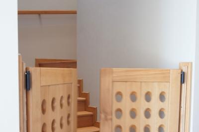 Chambre lumineuse avec deux lits, parquet au sol, murs clairs et fenêtres donnant sur un jardin verdoyant.