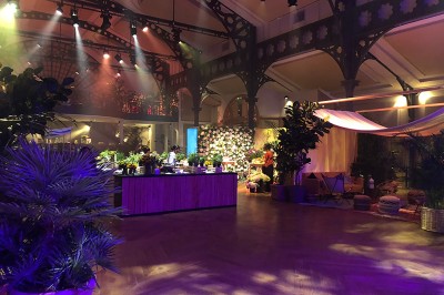 Salle intérieure avec mezzanine, escaliers symétriques, balustrades en métal décoratif et parquet au sol.
