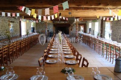 Trois petits chalets colorés en bois, entourés d'arbres et de pelouse, sous un ciel dégagé.