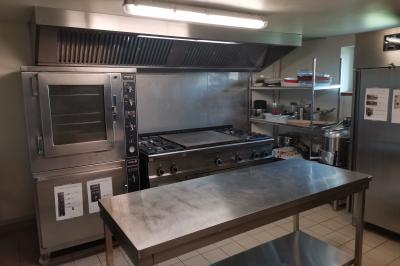 Trois petits chalets colorés en bois, entourés d'arbres et de pelouse, sous un ciel dégagé.