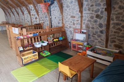 Trois petits chalets colorés en bois, entourés d'arbres et de pelouse, sous un ciel dégagé.