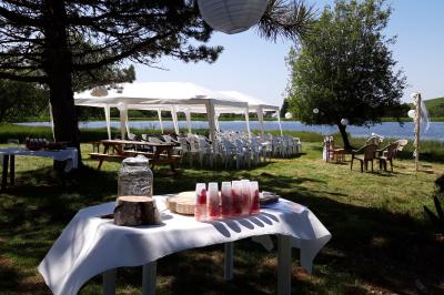 Trois petits chalets colorés en bois, entourés d'arbres et de pelouse, sous un ciel dégagé.