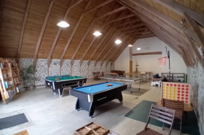 Trois petits chalets colorés en bois, entourés d'arbres et de pelouse, sous un ciel dégagé.