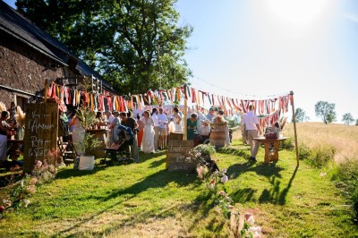 Trois petits chalets colorés en bois, entourés d'arbres et de pelouse, sous un ciel dégagé.