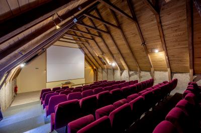 Trois petits chalets colorés en bois, entourés d'arbres et de pelouse, sous un ciel dégagé.