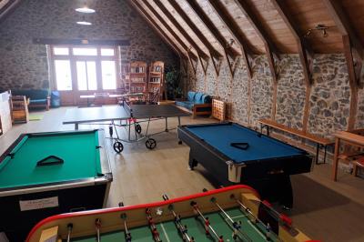 Trois petits chalets colorés en bois, entourés d'arbres et de pelouse, sous un ciel dégagé.