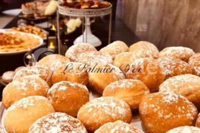 Salle de réception décorée avec une table dressée, un centre de table floral et une arche fleurie en arrière-plan.