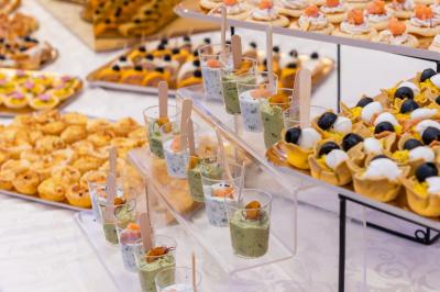 Salle de réception décorée avec une table dressée, un centre de table floral et une arche fleurie en arrière-plan.