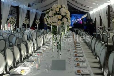Chambre d'hôtel lumineuse avec lit double, bureau bleu, fauteuil, télévision et balcon offrant une vue sur l'extérieur.