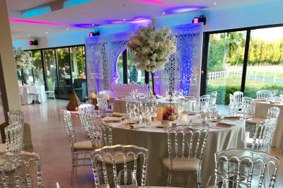 Chambre d'hôtel lumineuse avec lit double, bureau bleu, fauteuil, télévision et balcon offrant une vue sur l'extérieur.