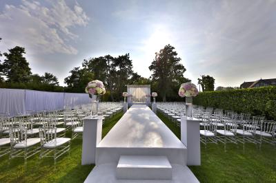 Chambre d'hôtel lumineuse avec lit double, bureau bleu, fauteuil, télévision et balcon offrant une vue sur l'extérieur.