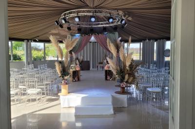 Chambre d'hôtel lumineuse avec lit double, bureau bleu, fauteuil, télévision et balcon offrant une vue sur l'extérieur.