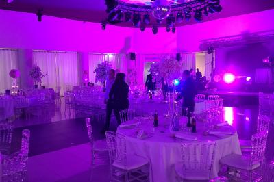 Chambre d'hôtel lumineuse avec lit double, bureau bleu, fauteuil, télévision et balcon offrant une vue sur l'extérieur.