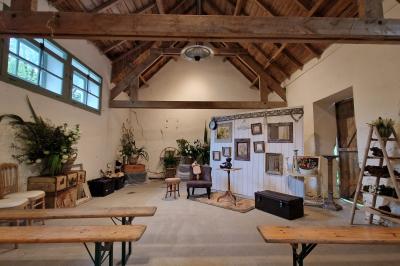 Salle de réception décorée avec des guirlandes lumineuses, remplie d'invités assis à des tables lors d'un événement.