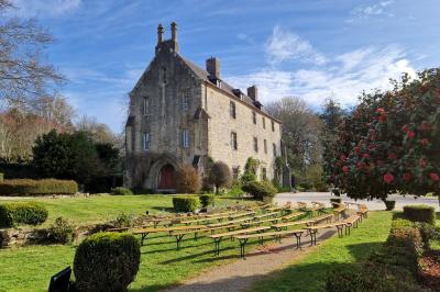 Salle de réception décorée avec des guirlandes lumineuses, remplie d'invités assis à des tables lors d'un événement.