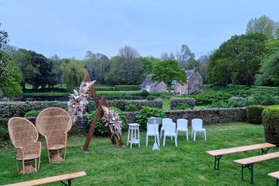 Salle de réception décorée avec des guirlandes lumineuses, remplie d'invités assis à des tables lors d'un événement.