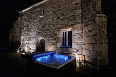 Chambre lumineuse avec un lit double, un mur bleu, une fenêtre avec rideaux jaunes et une porte en bois.