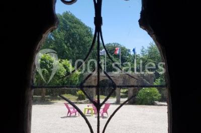 Salle de réception décorée avec des guirlandes lumineuses, remplie d'invités assis à des tables lors d'un événement.