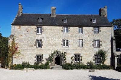 Salle de réception décorée avec des guirlandes lumineuses, remplie d'invités assis à des tables lors d'un événement.