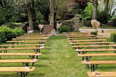 Salle de réception décorée avec des guirlandes lumineuses, remplie d'invités assis à des tables lors d'un événement.