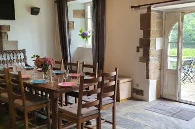 Chambre lumineuse avec un lit double, un mur bleu, une fenêtre avec rideaux jaunes et une porte en bois.