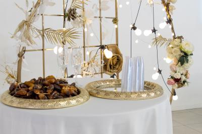 Buffet élégant avec une présentation variée de bouchées salées et sucrées sur des plateaux dorés en salle lumineuse.