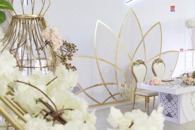 Buffet élégant avec une présentation variée de bouchées salées et sucrées sur des plateaux dorés en salle lumineuse.