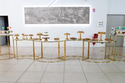 Buffet élégant avec une présentation variée de bouchées salées et sucrées sur des plateaux dorés en salle lumineuse.