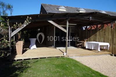 Voiture ancienne blanche décorée de fleurs blanches, stationnée sur un chemin près de vignes et d'un arbre.