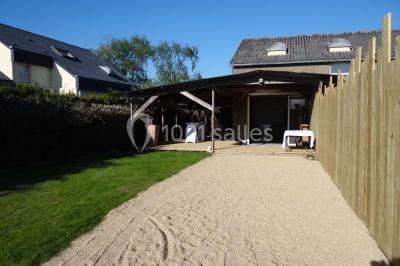 Voiture ancienne blanche décorée de fleurs blanches, stationnée sur un chemin près de vignes et d'un arbre.